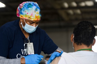 caption: A nurse administers the Moderna COVID-19 vaccine at a Veterans Administration Long Beach Healthcare System pop-up vaccination site at the Dae Hueng Presbyterian Church on Saturday in Gardena, Calif. More than half of U.S. adults have now received at least one vaccine dose.