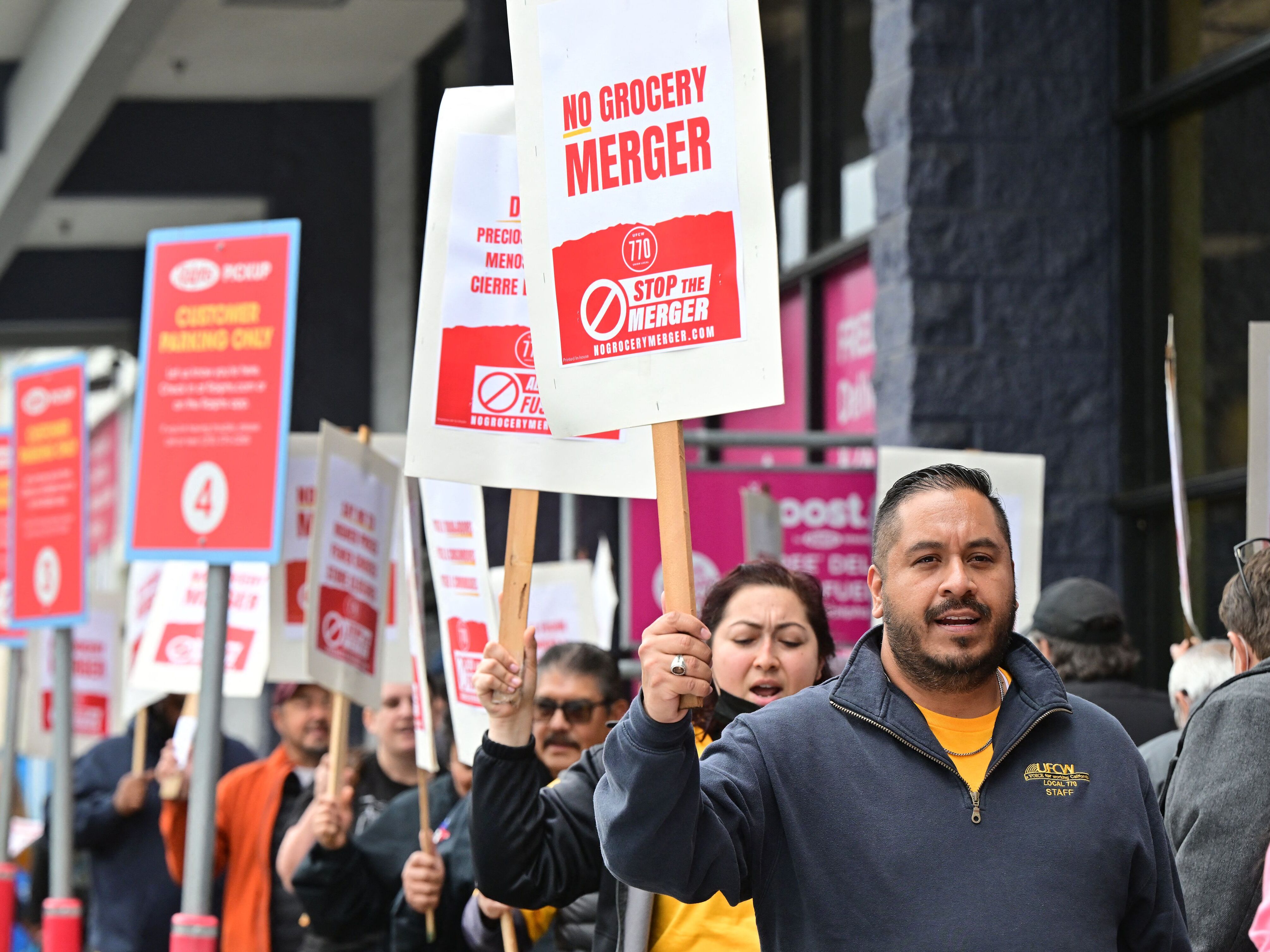 caption: Unionized grocery store workers rally to oppose the proposed merger between Kroger and Albertsons outside a Ralph's supermarket in Los Angeles in 2023. On Wednesday, Albertsons said it was giving up on the deal after it was blocked by two courts.