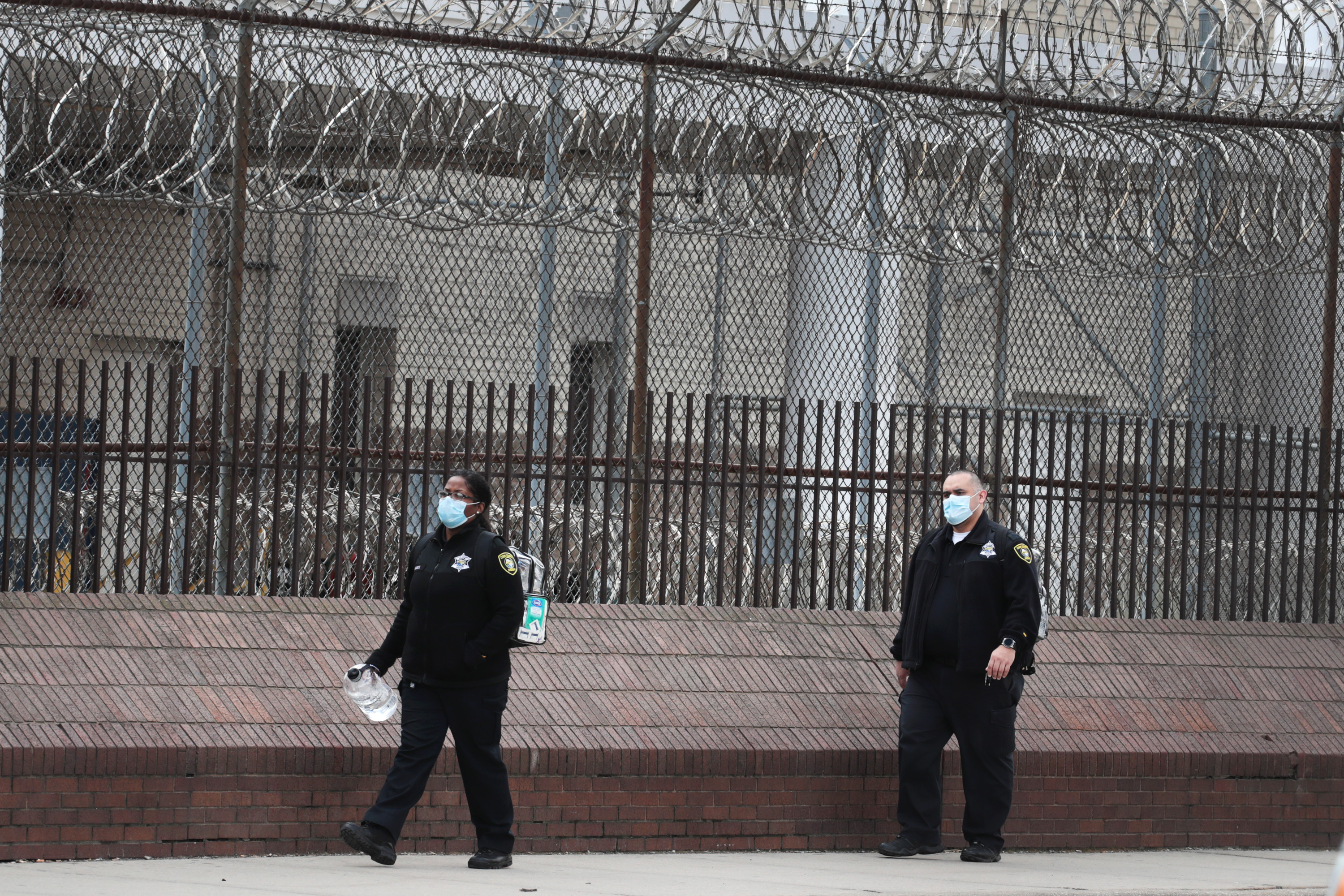 caption: People wearing protective masks leave the Cook County jail complex on April 09, 2020 in Chicago, Illinois. (Scott Olson/Getty Images)