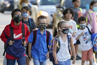 caption: Students arrive for the first day of school on Aug. 10 at Sessums Elementary School in Hillsborough County, Fla. After thousands of students were put in isolation or quarantine, the district is revisiting its safety protocols, including its mask-optional policy.