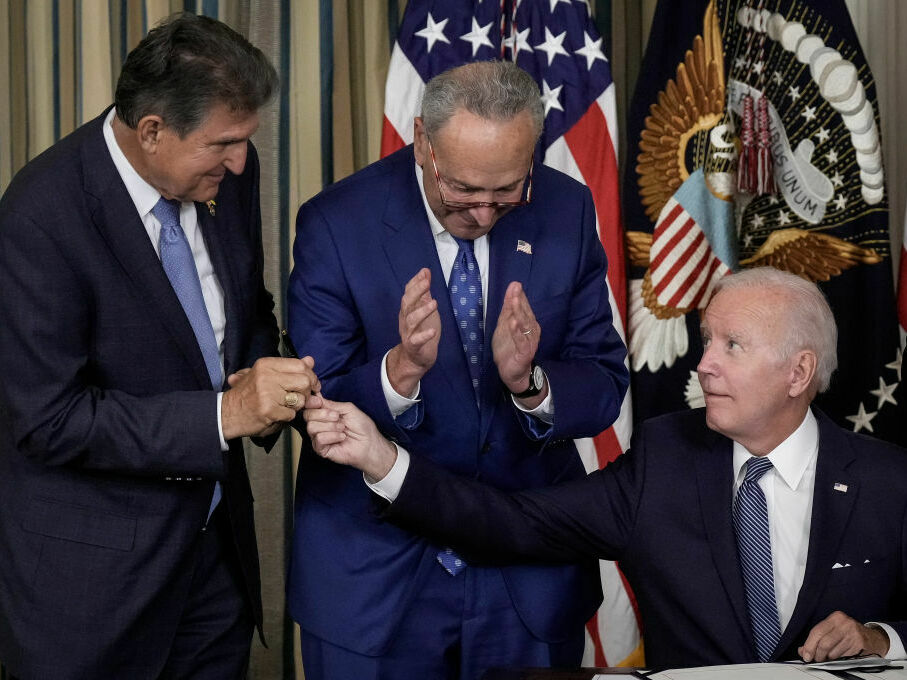 caption: President Biden gives Sen. Joe Manchin, D-W.Va., the pen he used to sign The Inflation Reduction Act with Senate Majority Leader Charles Schumer, D-N.Y., in the State Dining Room of the White House on Aug. 16, 2022.
