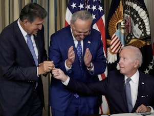 caption: President Biden gives Sen. Joe Manchin, D-W.Va., the pen he used to sign The Inflation Reduction Act with Senate Majority Leader Charles Schumer, D-N.Y., in the State Dining Room of the White House on Aug. 16, 2022.