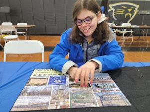 caption: Mora Leeb places some pieces into a puzzle during a local puzzle tournament. The 15-year-old has grown up without the left side of her brain after it was removed when she was very young.