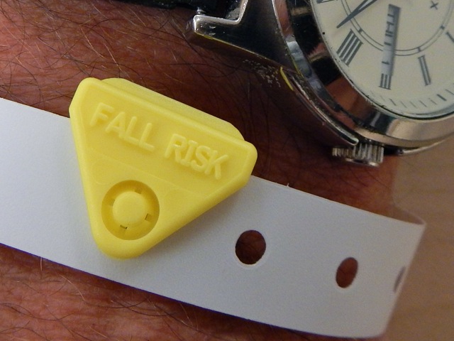 caption: Lester Reed of MultiCare models one of the wrist bands given to hospital patients at high risk of falling.