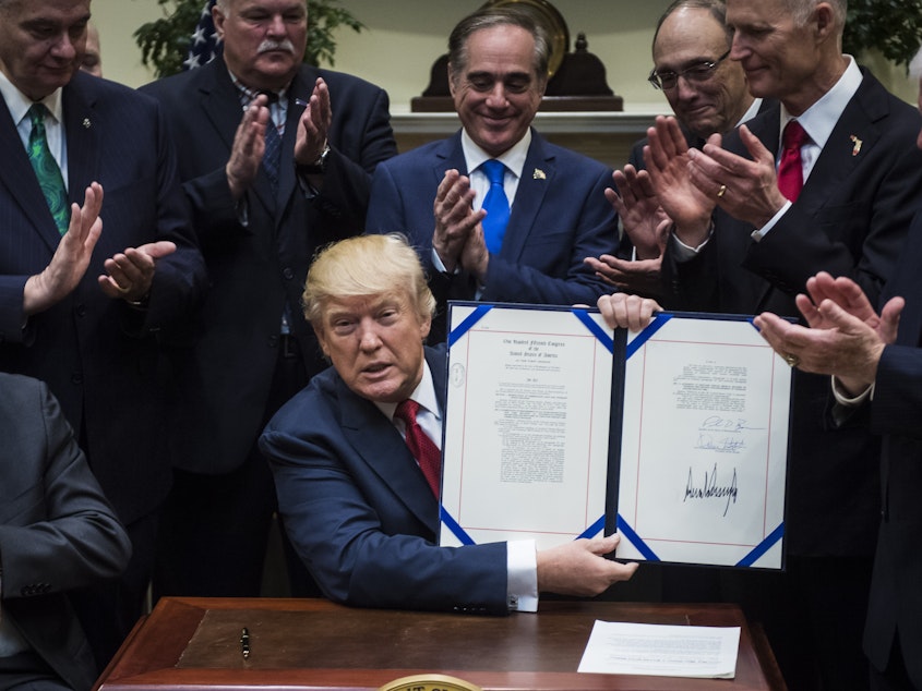 caption: President Trump shows off the Veterans Choice Program Extension and Improvement Act after signing it in April 2017. A new report said on Thursday that the agency failed in its core mission of protecting whistleblowers.
