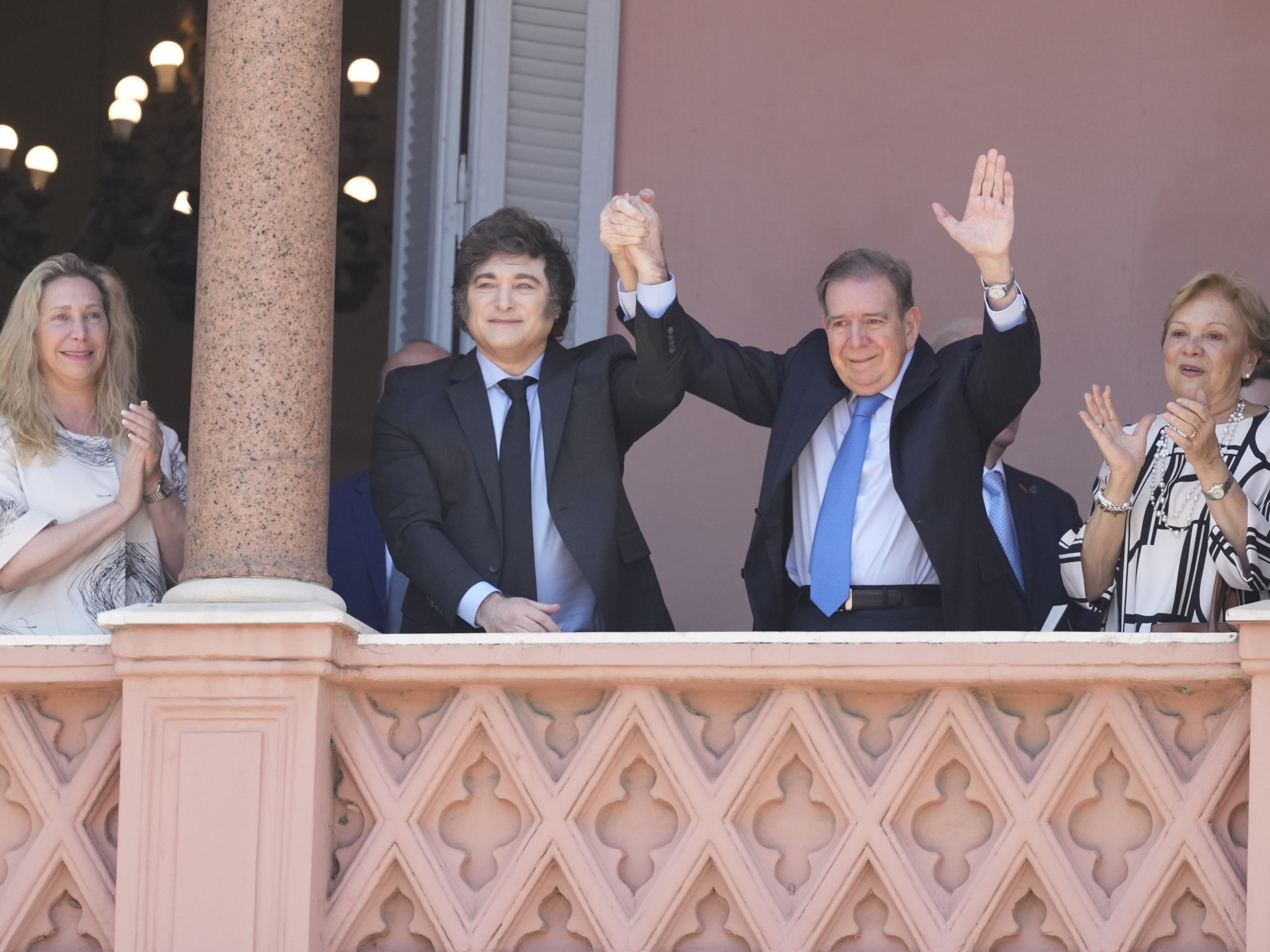 caption: Venezuela's opposition leader Edmundo Gonzalez Urrutia, center right, and Argentine President Javier Milei hold hands from the government house balcony in Buenos Aires, Argentina, Saturday, Jan. 4, 2025.