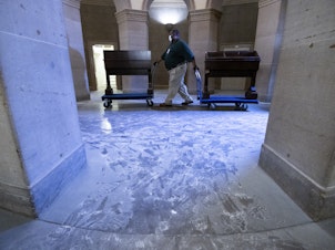 caption: Capitol workers remove damaged furniture on from the U.S. Capitol on January 7, 2021, following the riot at the Capitol the day before.