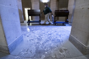 caption: Capitol workers remove damaged furniture on from the U.S. Capitol on January 7, 2021, following the riot at the Capitol the day before.
