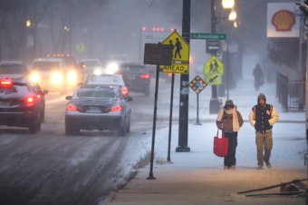 caption: Pedestrians navigate a snow-covered sidewalk in Chicago, on Thursday. Severe winter weather has impacted tens of millions of people in the U.S.