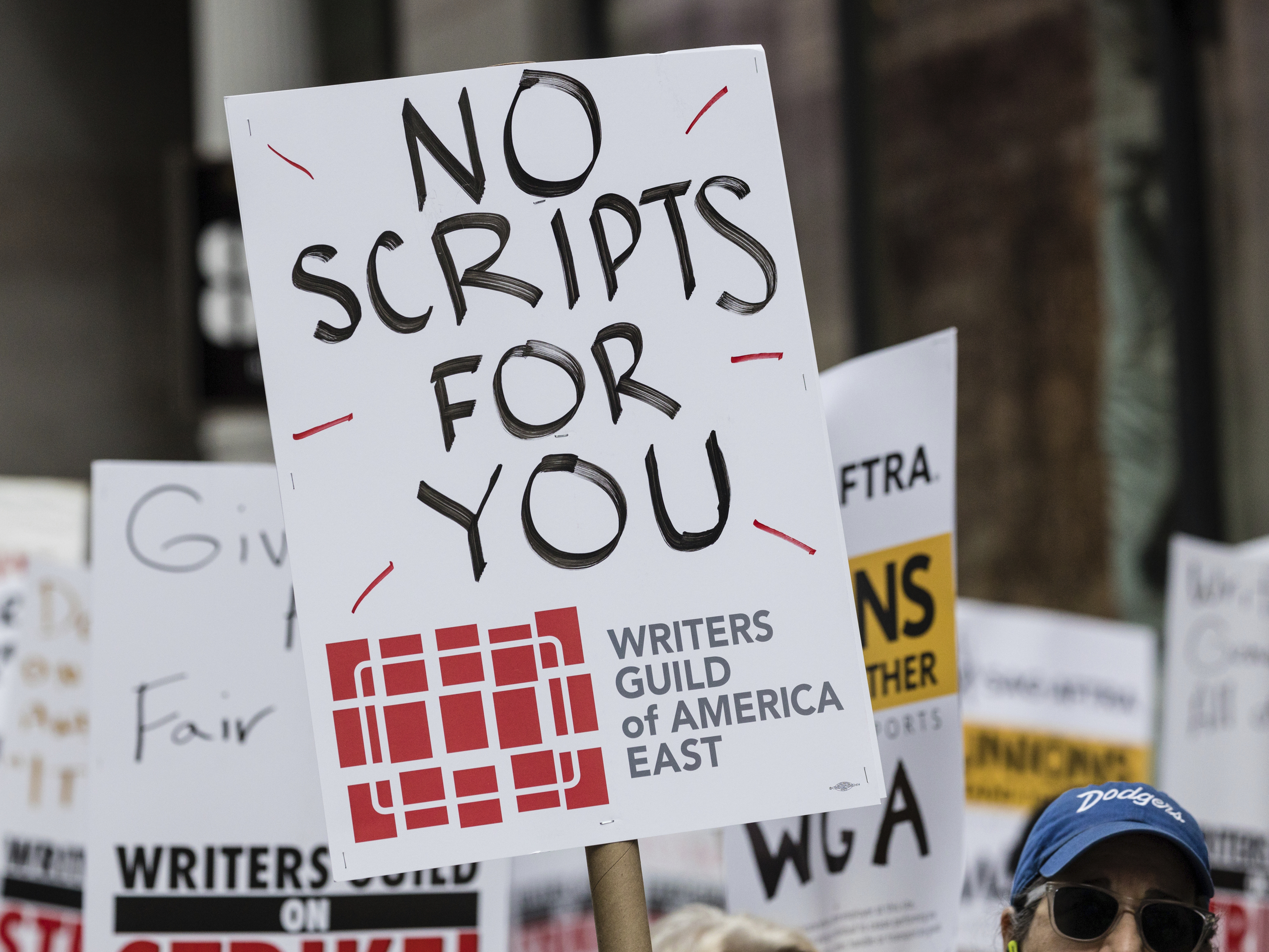 caption: Members of the Writers Guild of America union picket outside Netflix headquarters Wednesday near Union Square in New York.