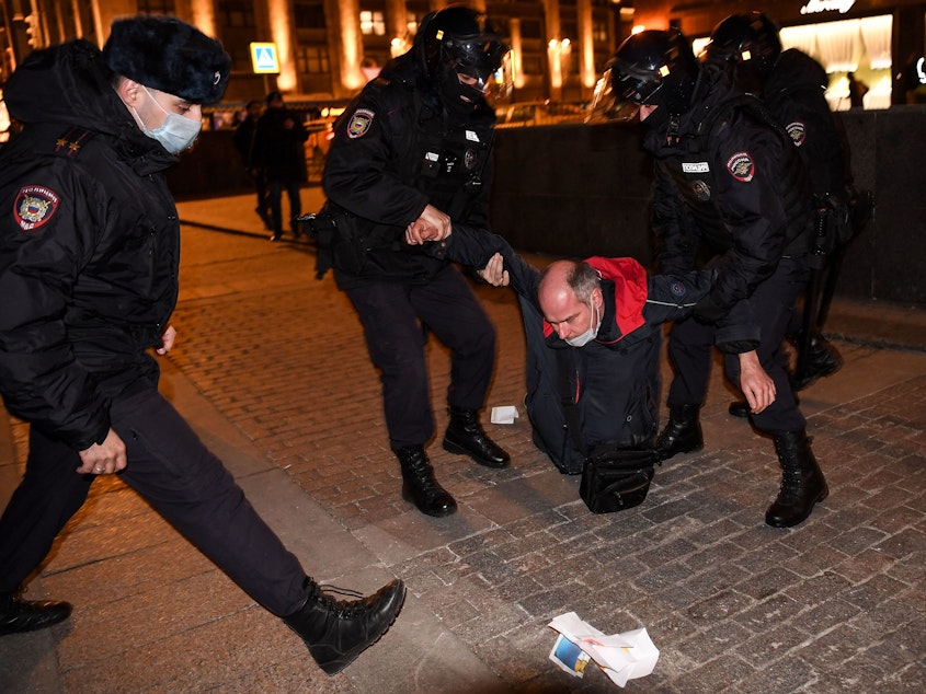 caption: Police officers detain a man during a protest in Moscow Thursday against Russia's invasion of Ukraine.