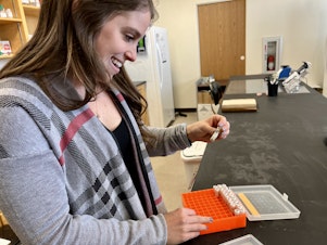 caption: Meghan Parsley looks at eDNA samples she's collected for her doctoral work. “I think eDNA is really changing how people think about monitoring and finding where things are,” she said.
