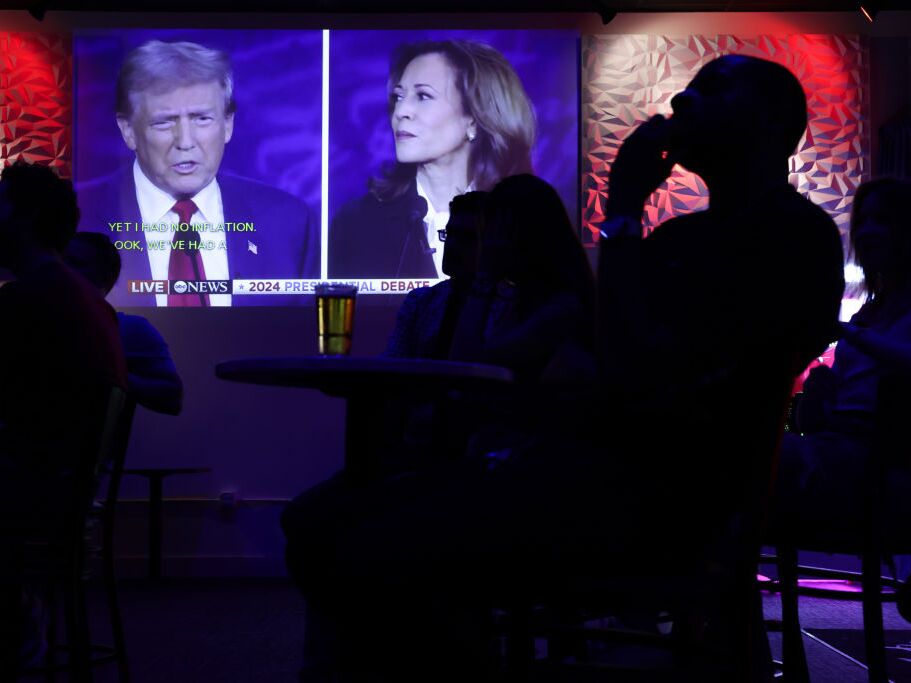 caption: People watch the presidential debate between Vice President Harris and former President Donald Trump during a debate watch party at Penn Social on Sept. 10 in Washington, D.C. 
