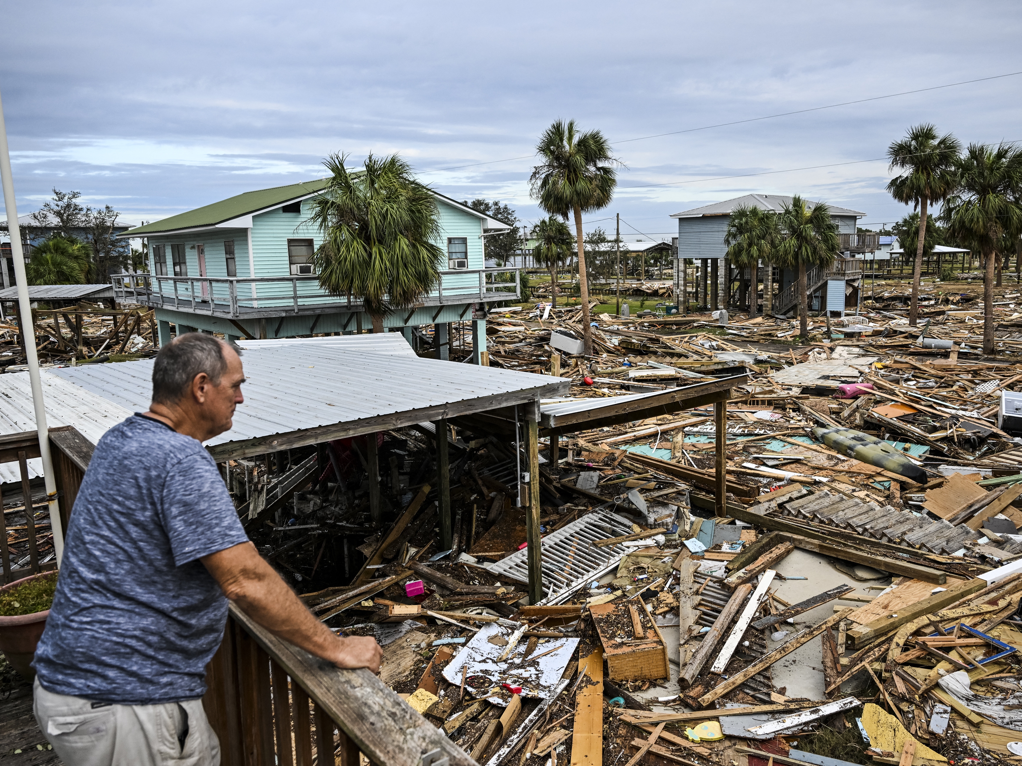 caption: David Hester inspects damages of his house on Saturday after Hurricane Helene made landfall in Horseshoe Beach, Fla.