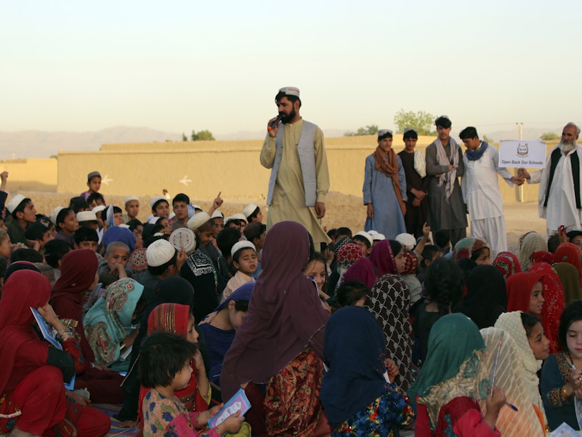 caption: Matiullah Wesa, a girls' education advocate, reads to students in Spin Boldak district in Kandahar province of Afghanistan on May 21, 2022. The Taliban have freed the Afghan activist who campaigned for the education of girls, a local nonprofit organization said Thursday. Wesa was arrested seven months ago and spent 215 days in prison, according to the group, Pen Path.