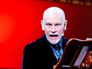 caption: John Malkovich says theater is like surfing. Actors might think they are the wave — but they're not: "The wave is created by the collision between the material and the public. You ride the wave or you don't." Malkovich is pictured above in <em>The Music Critic.</em>