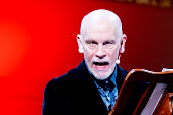 caption: John Malkovich says theater is like surfing. Actors might think they are the wave — but they're not: "The wave is created by the collision between the material and the public. You ride the wave or you don't." Malkovich is pictured above in <em>The Music Critic.</em>