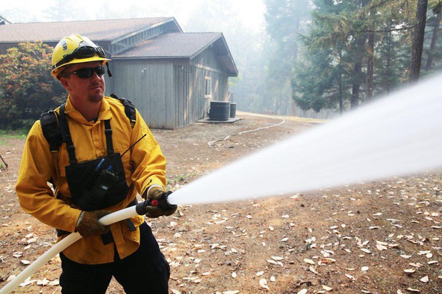 caption: <p>Klamath County firefighter Jeff Frost runs a structure protection drill at a home on a secluded cul-de-sac near the Rogue River. Its owners evacuated as the Taylor Creek Fire burned closer.</p>