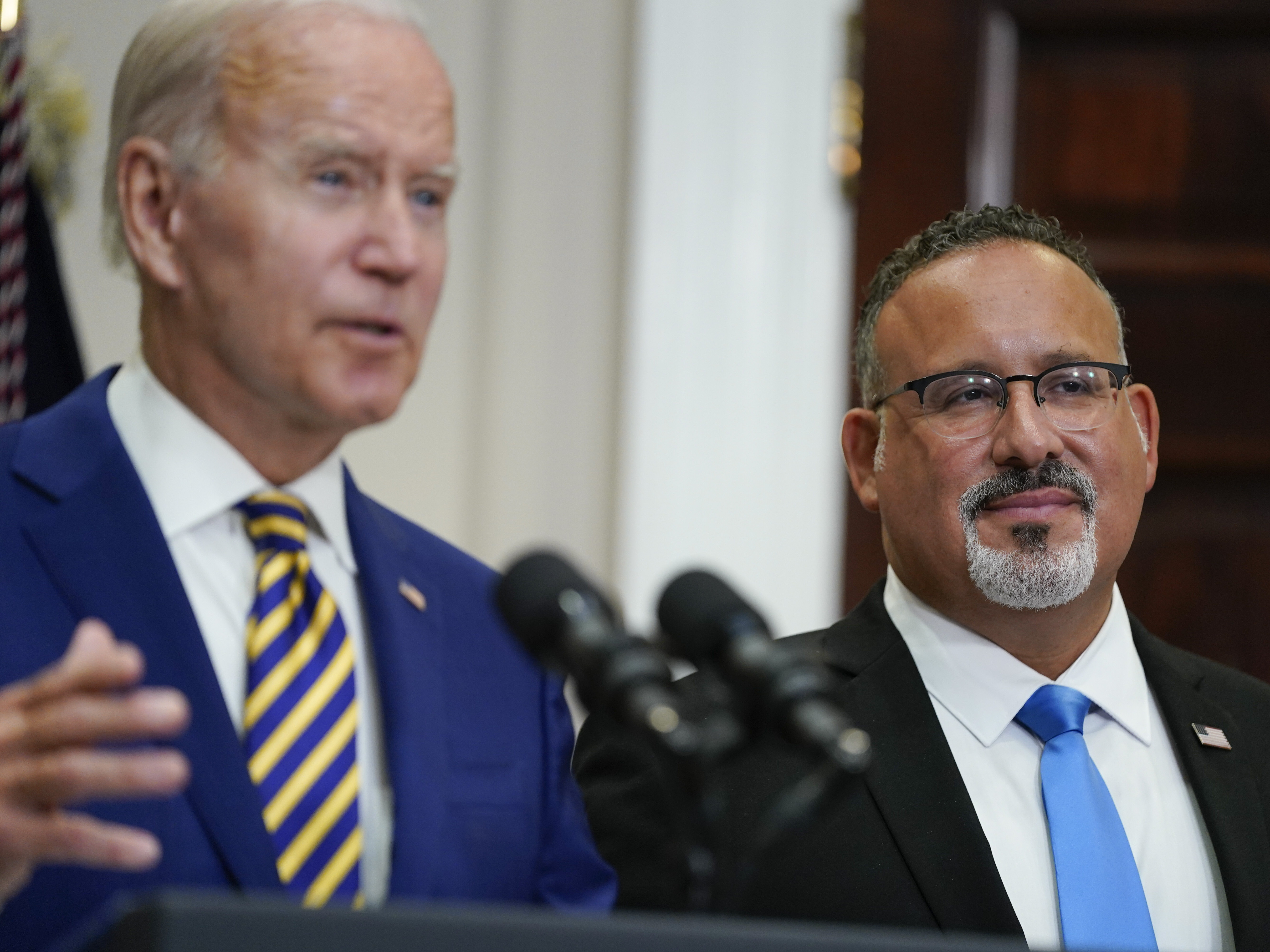 caption: U.S. Education Secretary Miguel Cardona appeared alongside President Biden when he announced his student loan relief plan on Aug. 24. On Thursday, the administration quietly changed its guidance around which borrowers qualify for this relief.