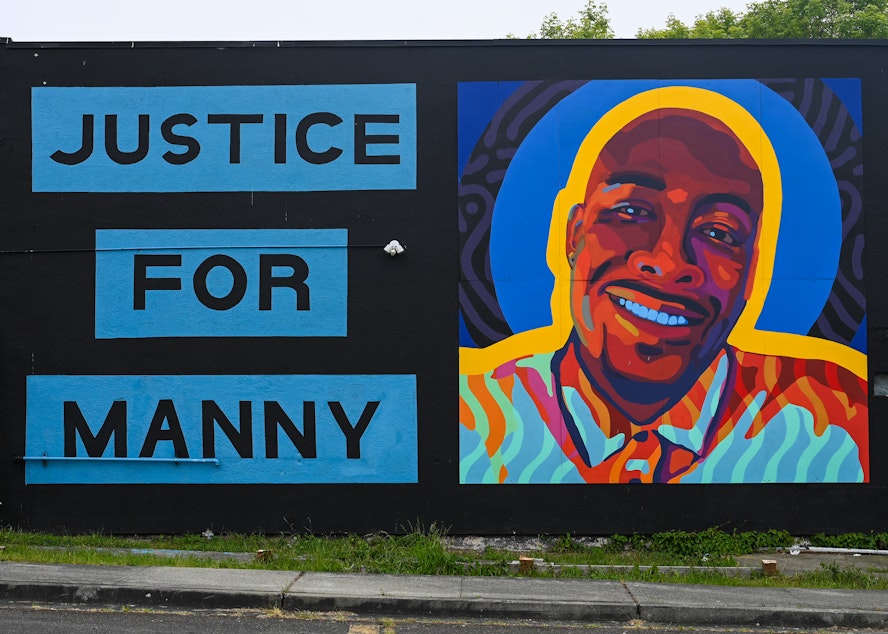 caption: A mural honoring 33-year-old Manuel Ellis at the intersection of Martin Luther King Jr. Way and South 11th street in Tacoma.