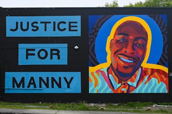 caption: A mural honoring 33-year-old Manuel Ellis at the intersection of Martin Luther King Jr. Way and South 11th street in Tacoma.