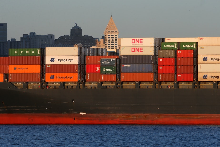 caption: The Smith Tower rises above Liberian container ship Nyk Deneb, September 1, 2021. The Northwest Seaport Alliance is the fifth largest shipping port in the United States and handled $66 billion in trade in 2020.