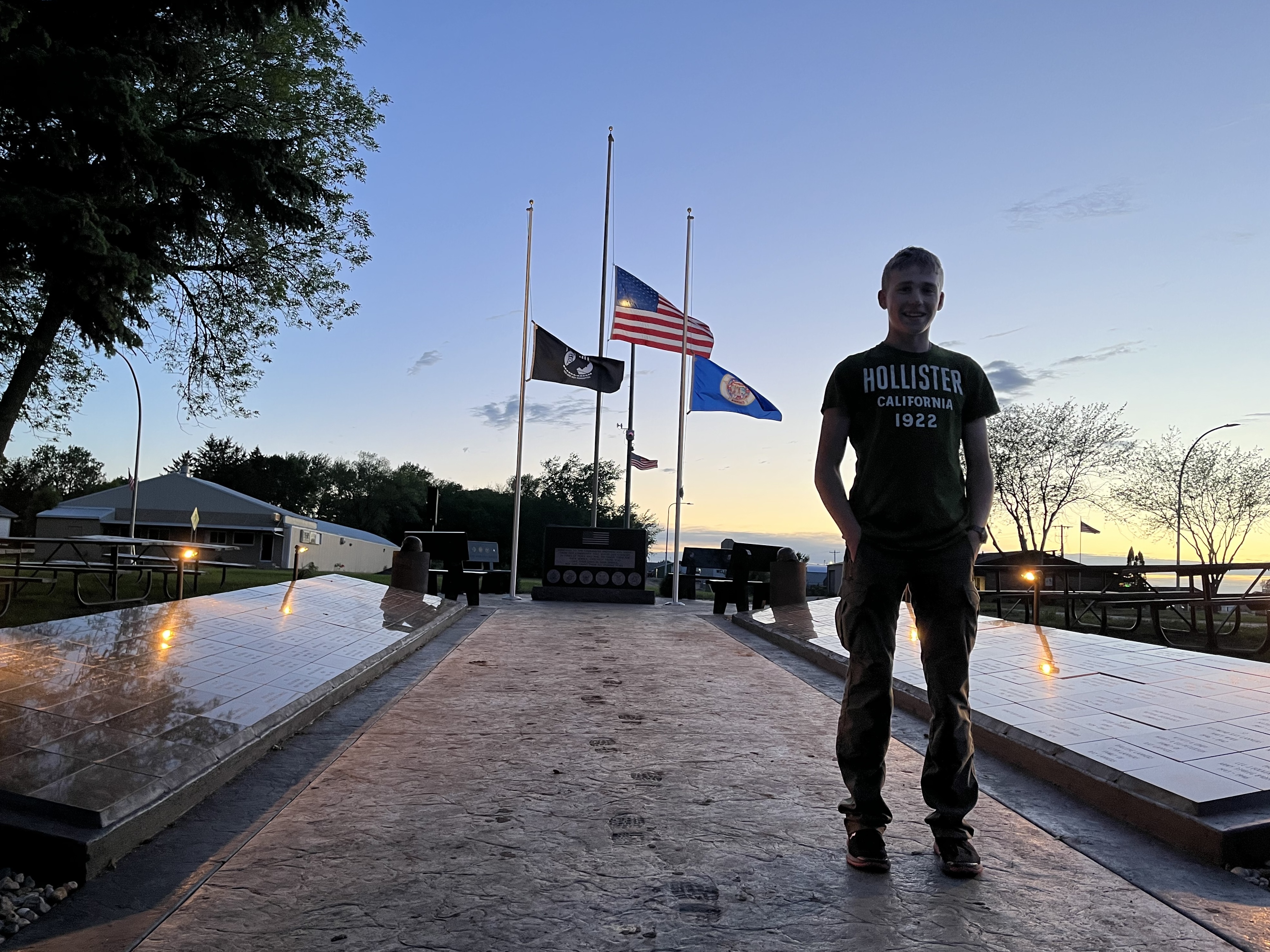 caption: Dominique Claseman stands in front of the memorial he built for his Eagle Scouts project.