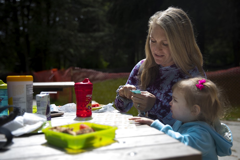 caption: Julie Wright and her daughter Stella, age 2, eat lunch at the Discovery Park play area on Wednesday. 