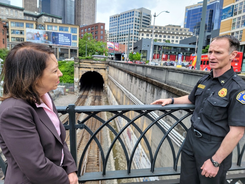 caption: Washington Senator Maria Cantwell and Seattle Fire Battalion Chief Andy Collins inspect the rain tunnel entrance in Pioneer Square on Monday, May 22, 2023.
