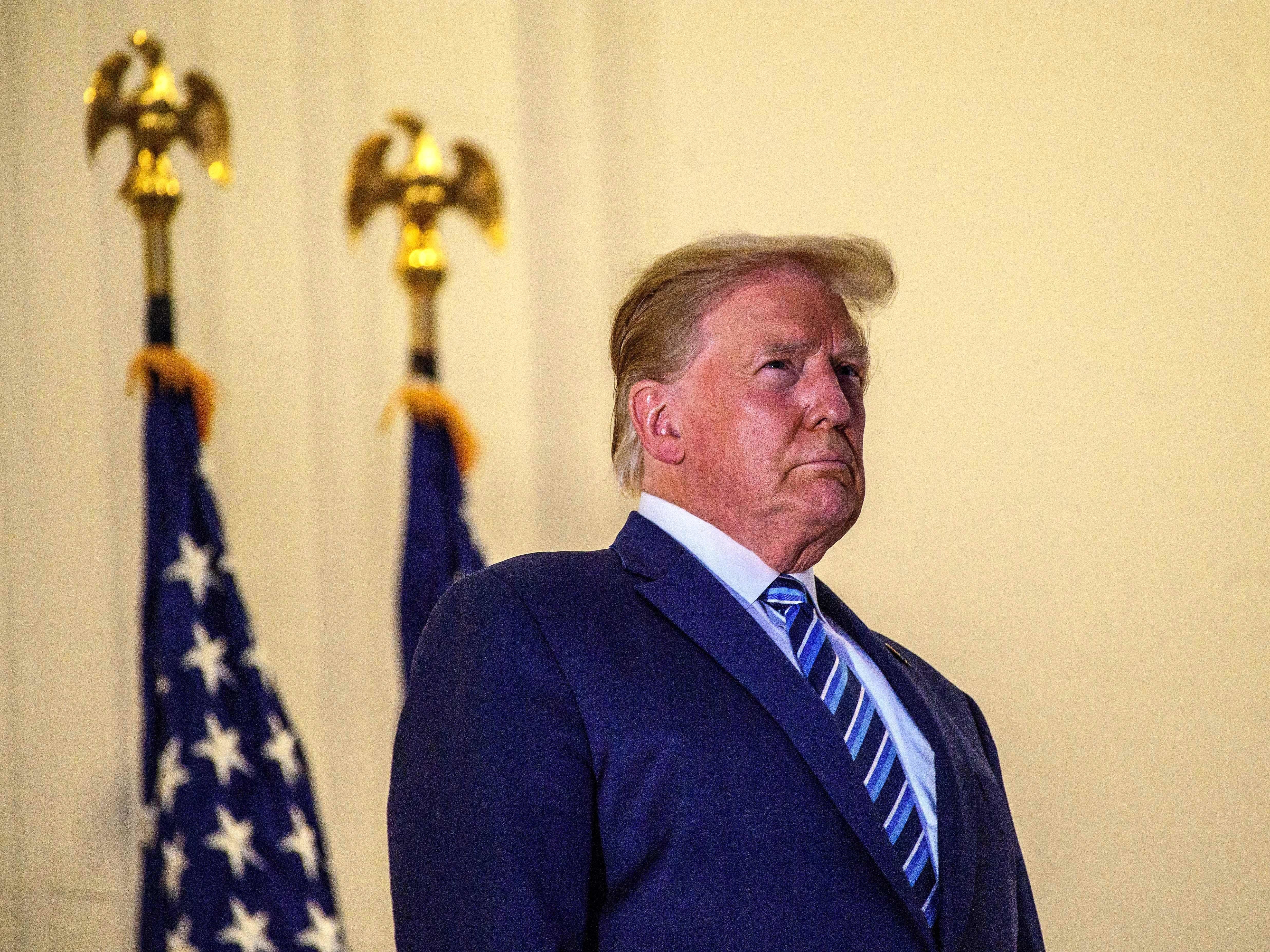 caption: President Trump looks out from the White House after his release from Walter Reed Medical Center this week.