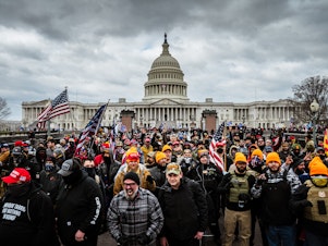 caption: Pro-Trump rioters, including members of the far-right extremist group the Proud Boys, gather near the U.S. Capitol on Jan. 6. At least 25 people charged in the attack appear to have links to the Proud Boys, according to court documents.