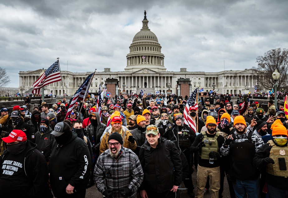 caption: Pro-Trump rioters, including members of the far-right extremist group the Proud Boys, gather near the U.S. Capitol on Jan. 6. At least 25 people charged in the attack appear to have links to the Proud Boys, according to court documents.