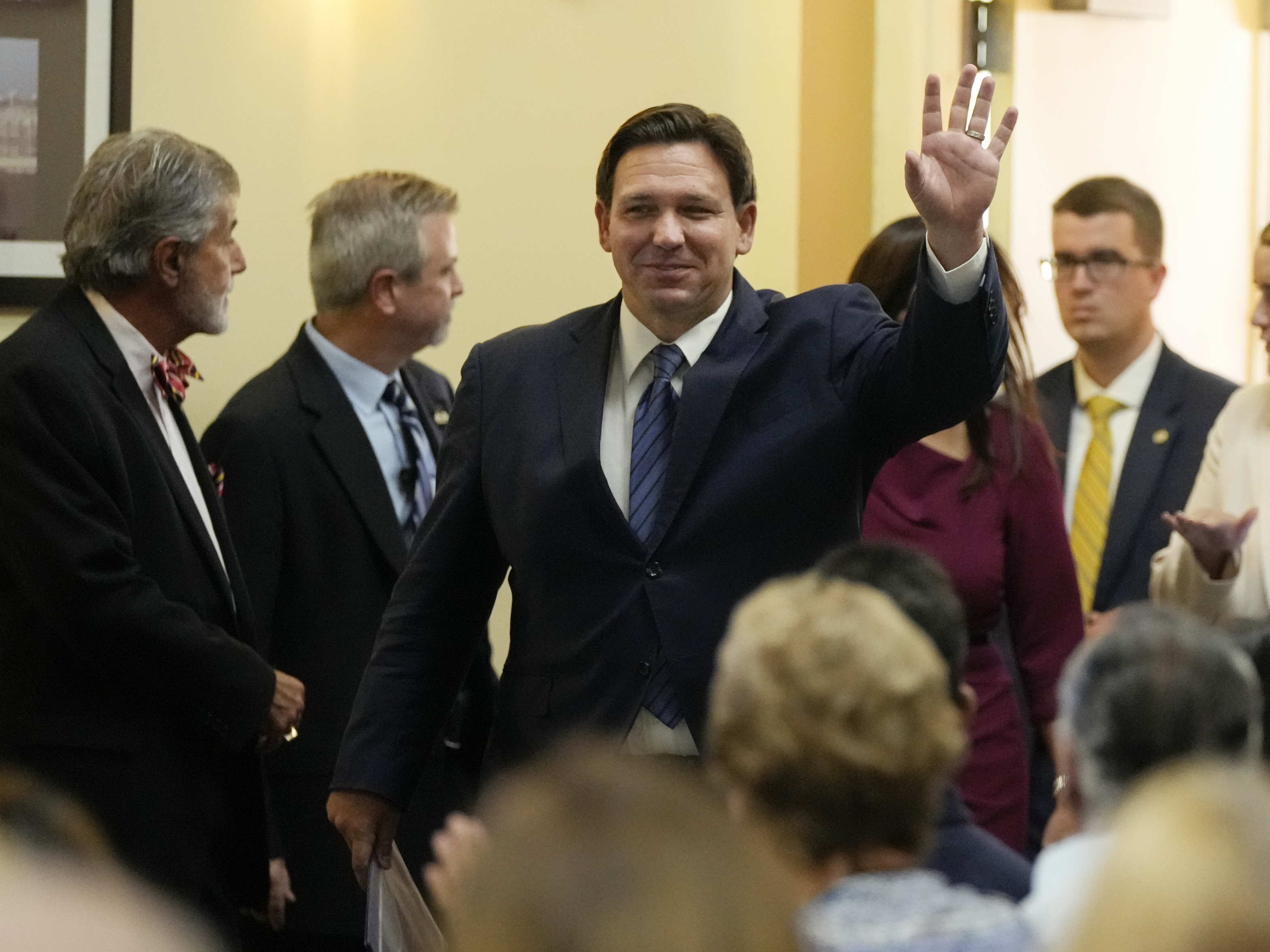 caption: Florida Gov. Ron DeSantis waves as he arrives for a news conference on Sept. 7.