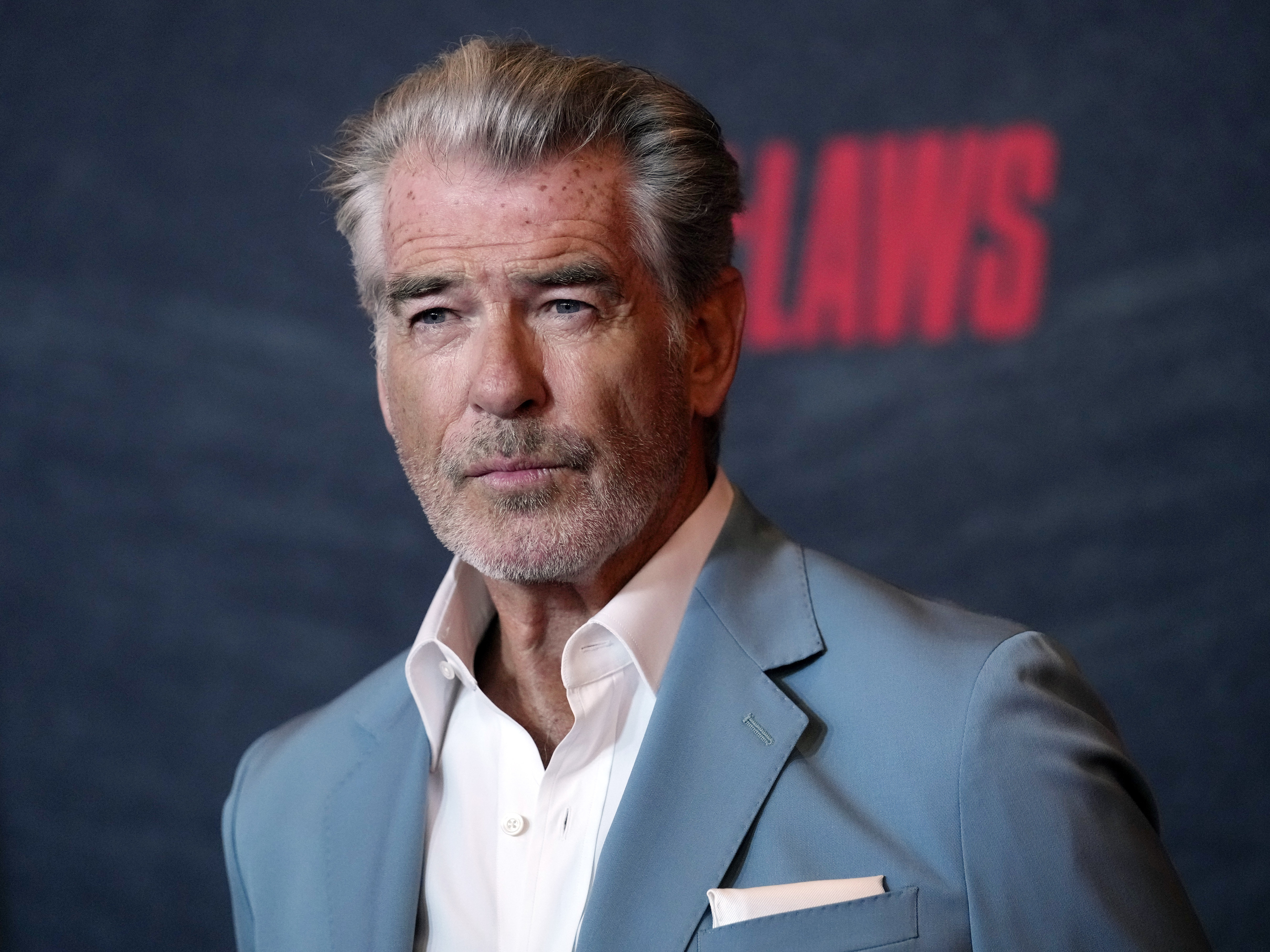 caption: Pierce Brosnan, a cast member in "The Out-Laws," poses at a screening of the film, on June 26, 2023, in Los Angeles. Brosnan pleaded guilty Thursday to stepping out of bounds in a thermal area during a November 2023 visit to Yellowstone National Park.