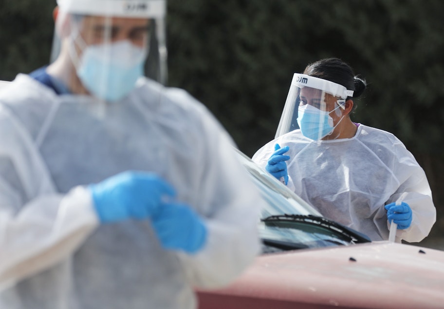 caption: Frontline healthcare workers work at a drive-in COVID-19 testing site amid a surge of COVID-19 cases in El Paso on November 13, 2020. (Mario Tama/Getty Images)