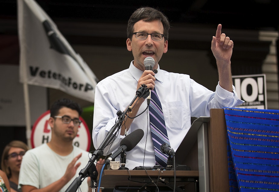 caption: FILE: Attorney General Bob Ferguson speaks during a community rally in support of DACA recipients on Tuesday, September 5, 2017, at El Centro De La Raza in Seattle. 