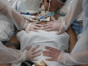 caption: Nurses perform timed breathing exercises on a COVID-19 patient on a ventilator in the COVID-19 intensive care unit at the la Timone hospital in Marseille, southern France on Dec. 31, 2021.