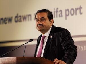 caption: Gautam Adani, billionaire and chairman of Adani Group, speaks during an event at Israel's Port of Haifa, on Tuesday. The Indian billionaire, whose business empire was rocked by allegations of fraud by short seller Hindenburg Research, said his company will make more investments in Israel.