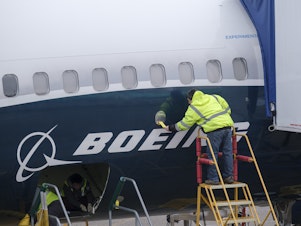 caption: An Boeing employee works on the fuselage of a 737 Max 9 test plane at the company's factory in Renton, Wash., on March 14. Orders for durable goods jumped 2.7% last month, fueled in part by strong demand for commercial aircraft.