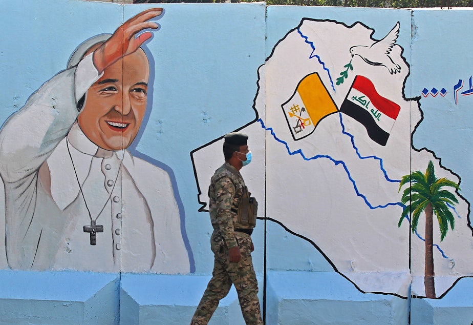 caption: An Iraqi policeman walks by a mural depicting Pope Francis on the outer walls of Our Lady of Salvation Church in Baghdad on Monday. Pope Francis' visit from March 5 to 8 will include trips to Baghdad, the city of Mosul and a meeting with the country's top Shiite cleric Grand Ayatollah Ali al-Sistani.