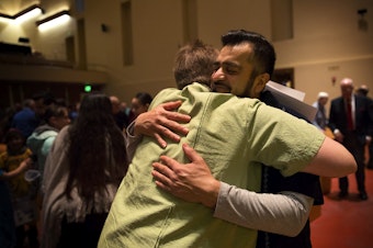 caption: FILE PHOTO: Jose Robles, right, hugs Pastor Kari Lipke on Sunday, December 16, 2018, after the Las Posadas Pageant at Gethsemane Lutheran Church in Seattle. 