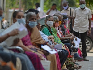 caption: People wait their turn to receive the COVID-19 vaccine at a government hospital in Chennai, India, in April. India is among the nations which will receive surplus U.S. vaccine through the international distribution system COVAX, the White House announced.