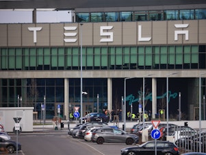 caption: The Tesla Inc. Gigafactory in Grünheide, Germany, on Tuesday. The company halted production at its factory outside of Berlin and sent workers home after suspected arson at a nearby high-voltage pylon caused power failures throughout the region.