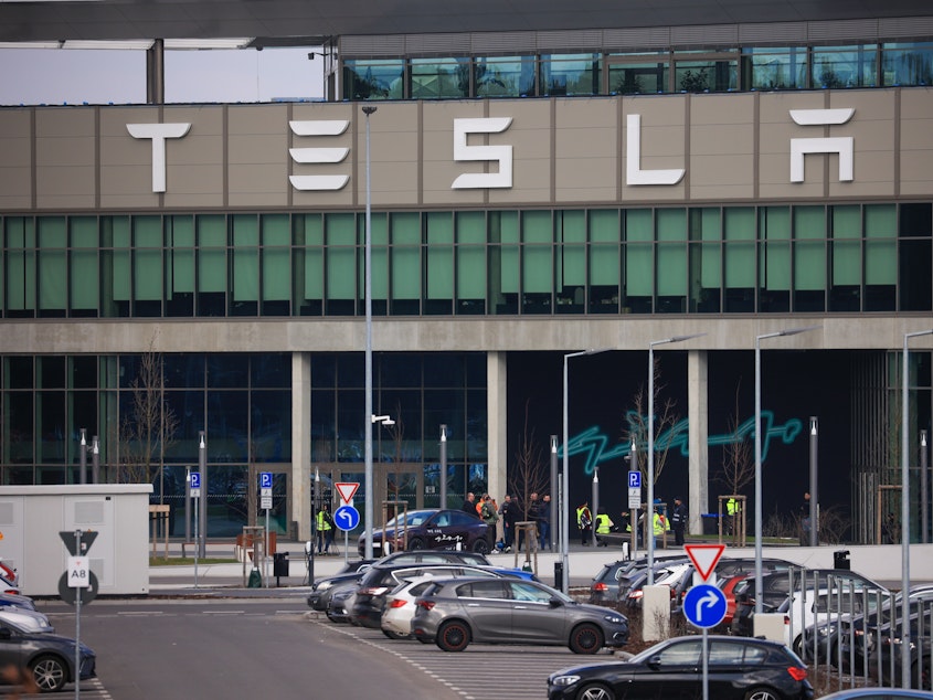 caption: The Tesla Inc. Gigafactory in Grünheide, Germany, on Tuesday. The company halted production at its factory outside of Berlin and sent workers home after suspected arson at a nearby high-voltage pylon caused power failures throughout the region.