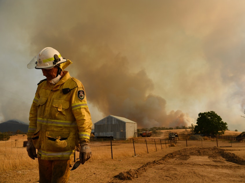 caption: Rural Fire Service (RFS) firefighter Trevor Stewart views the flank of a fire on January 11, 2020 in Tumbarumba, Australia.