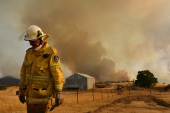 caption: Rural Fire Service (RFS) firefighter Trevor Stewart views the flank of a fire on January 11, 2020 in Tumbarumba, Australia.