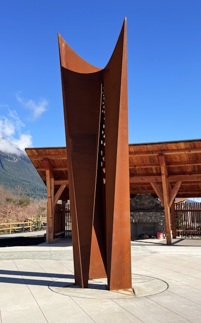 caption: The Oso Slide Memorial features a steel sculpture designed by Seattle artist Tsovinar Muradyan. Every year on the anniversary of the slide, at 10:37 in the morning, if the skies are clear, the sun’s rays pass through the sculpture and land on a boulder dislodged by the slide.