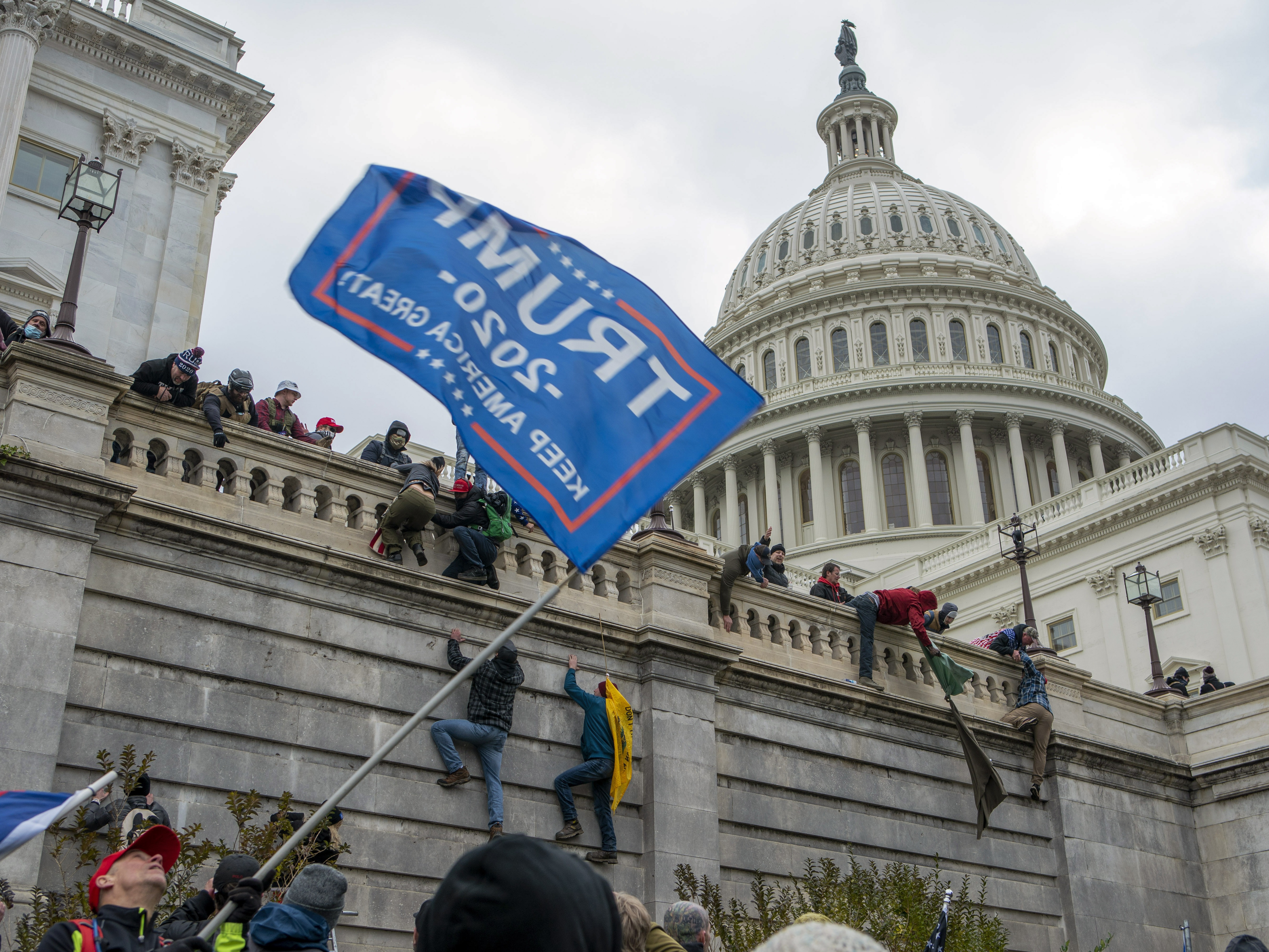 caption: Supporters of President Donald Trump climb the West wall of the the U.S. Capitol, Jan. 6, 2021, in Washington.