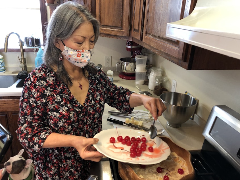 caption: Lucy Garcia puts the finishing touches on her fruit salad, a holiday staple similar to the American ambrosia. 