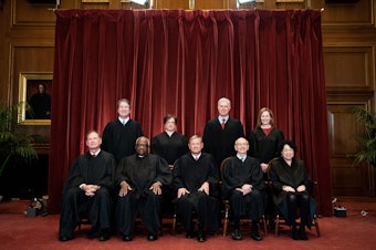 caption: A group photo of the justices at the Supreme Court in Washington on April 23, 2021. Seated from left: Samuel Alito, Clarence Thomas, John Roberts, Stephen Breyer and Sonia Sotomayor. Standing from left: Brett Kavanaugh, Elena Kagan, Neil Gorsuch and Amy Coney Barrett.